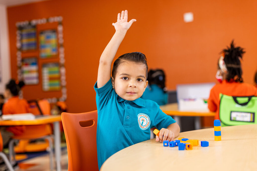 Young student raising hand in classroom setting