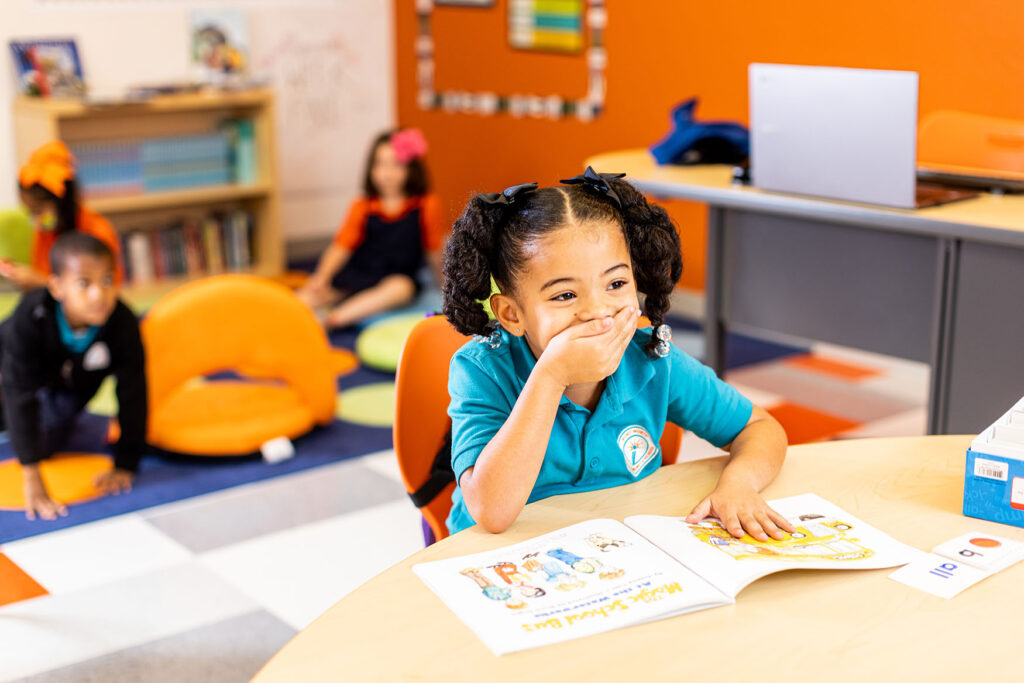 Child reading book in colorful classroom setting