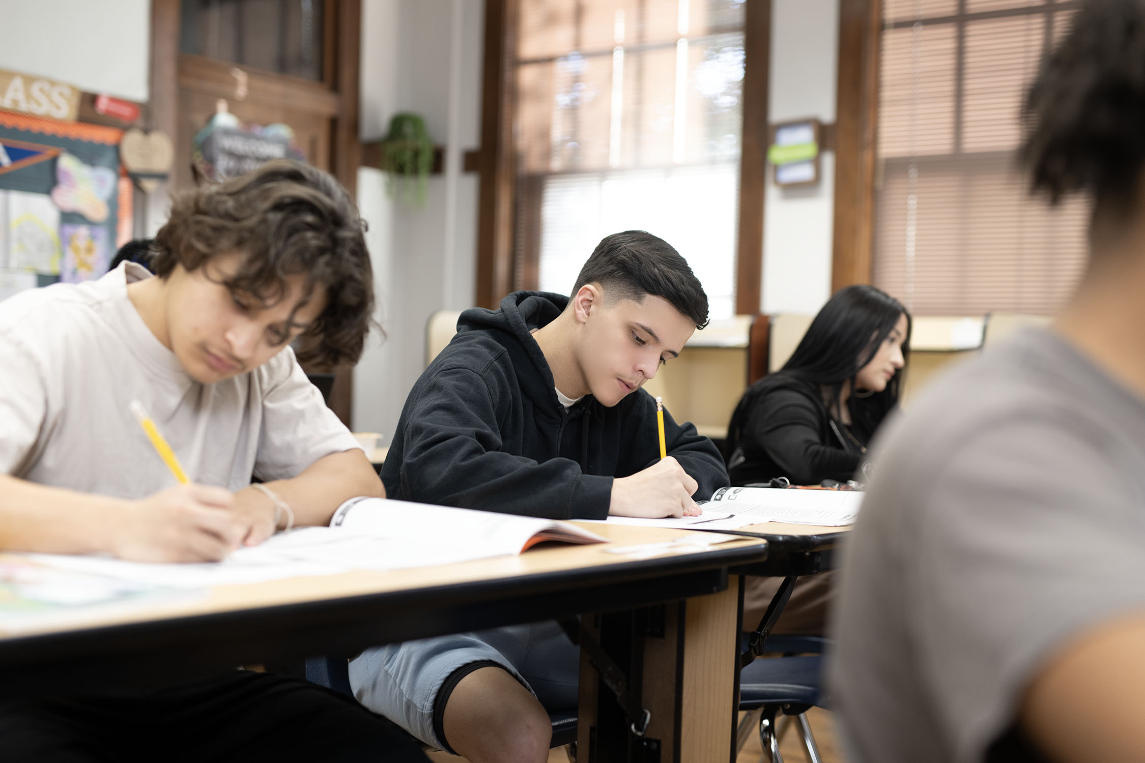 Students focused on writing in classroom setting