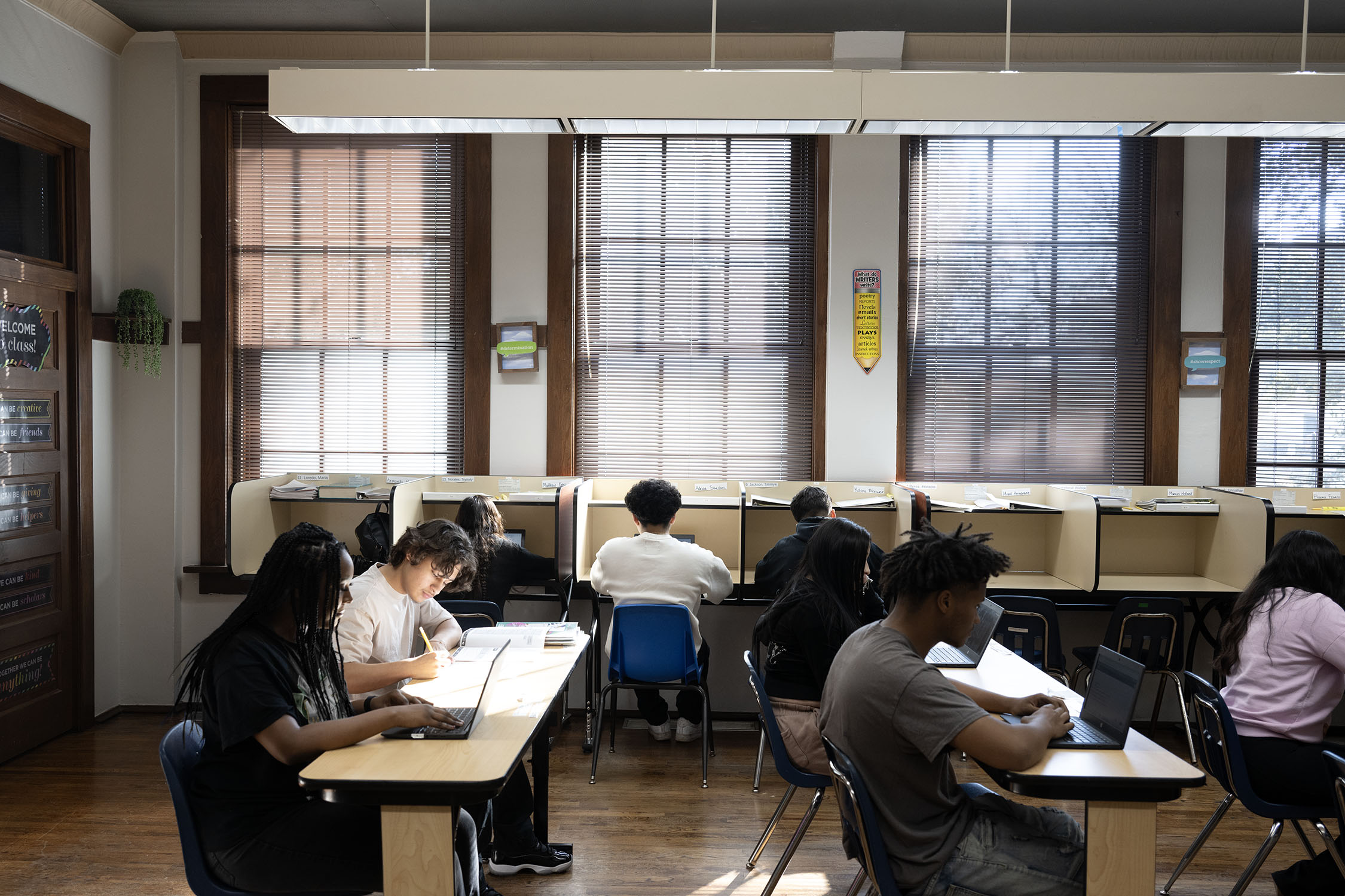 Students studying in well-lit spacious library hall.