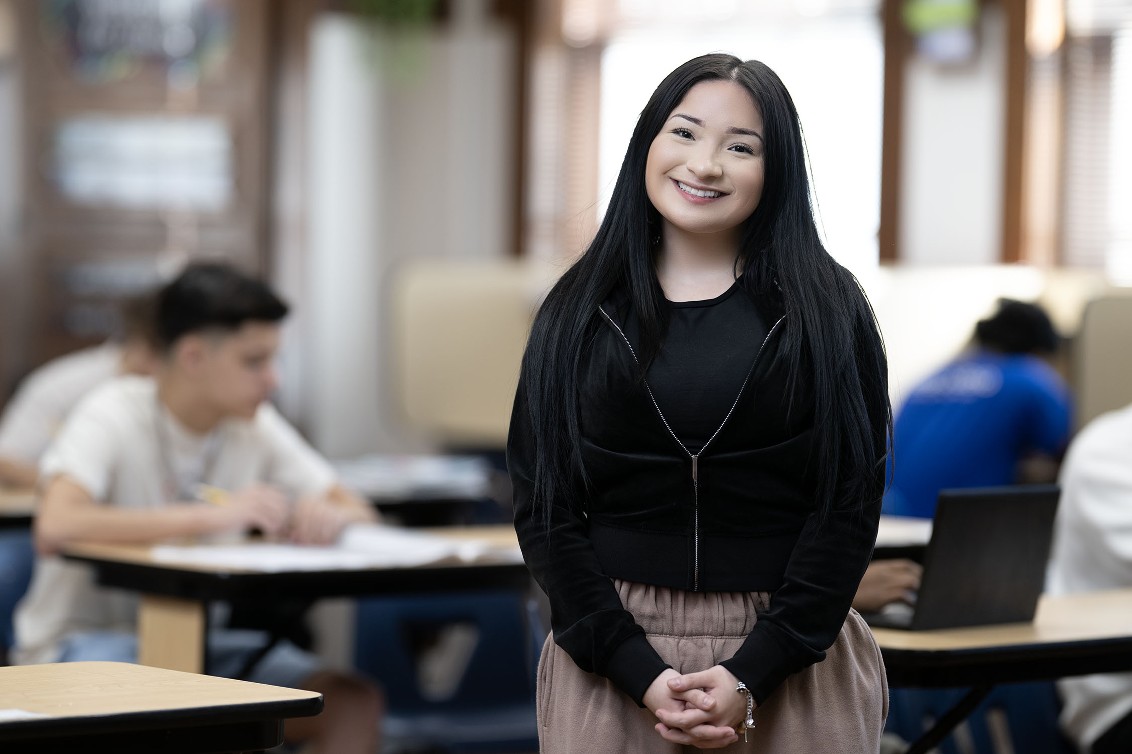 Smiling young woman standing in a classroom setting