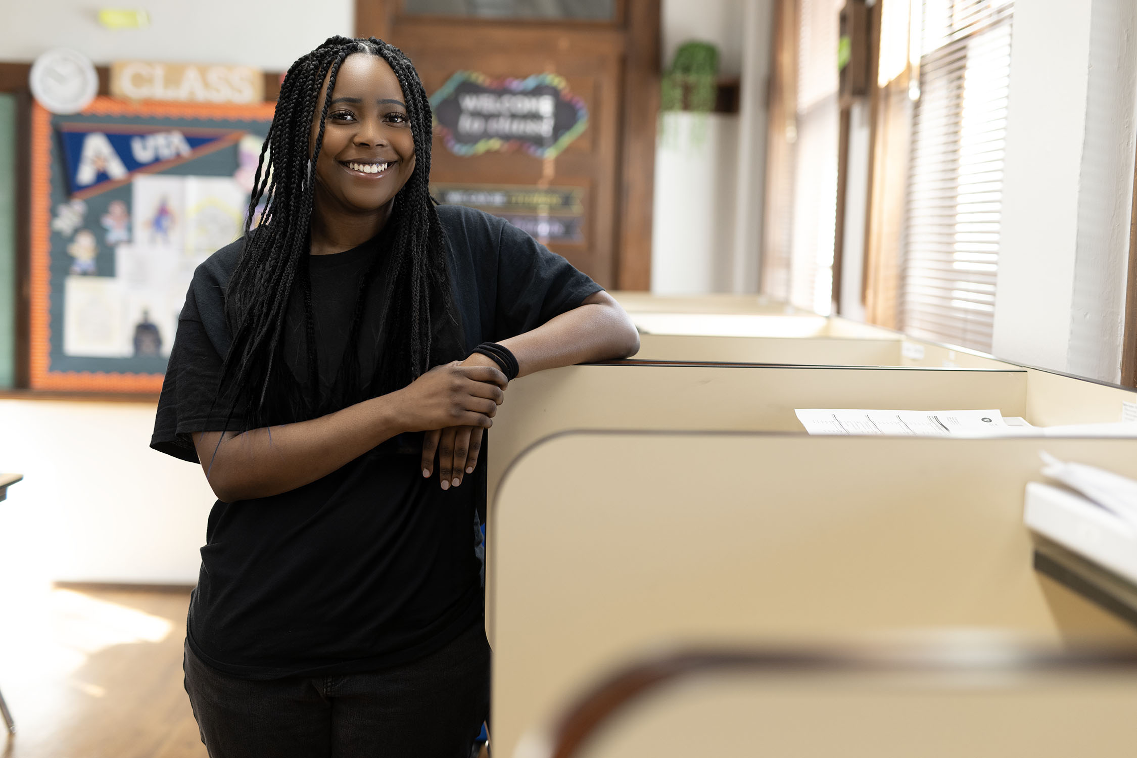 Confident woman standing in a classroom setting.