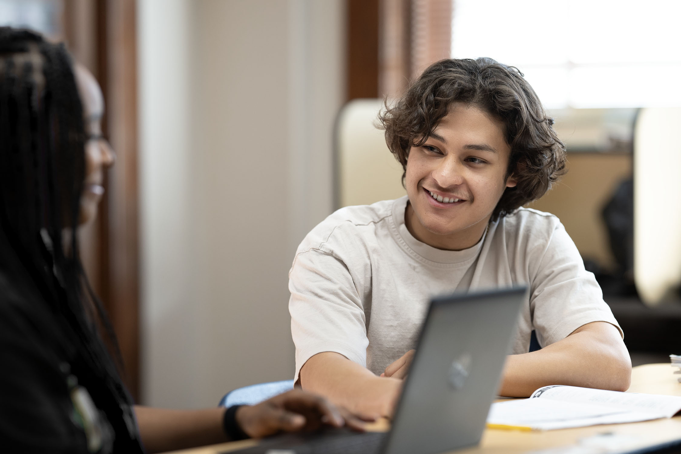 Young man and colleague working together with laptop