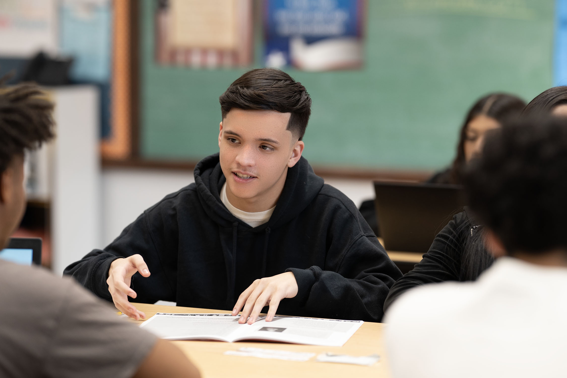 Teenage student participating in classroom discussion.