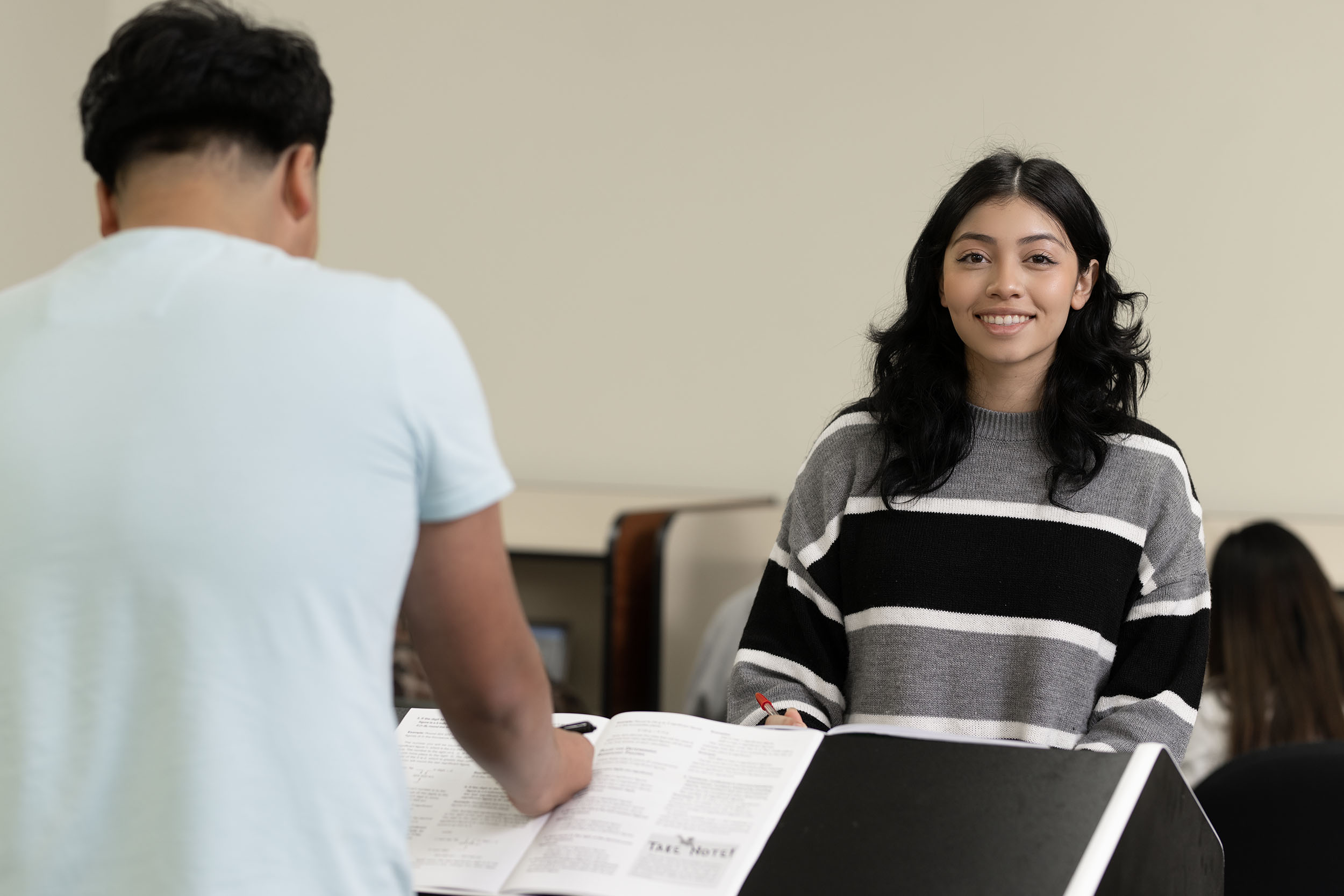 Young woman smiling during a classroom discussion