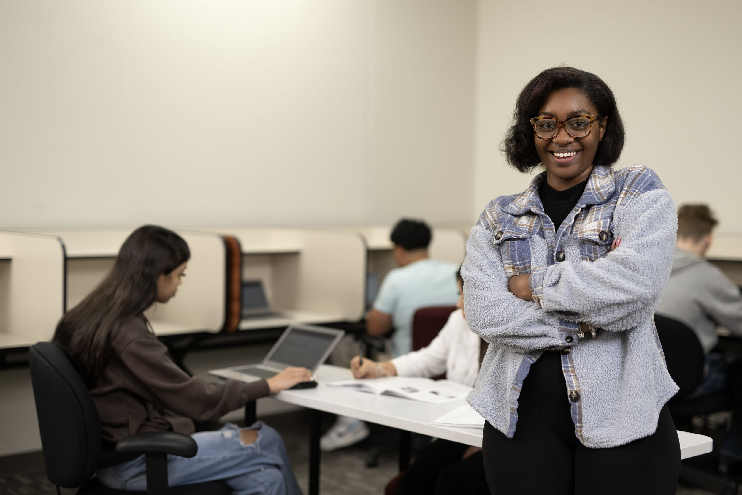Confident student smiling in university classroom setting.