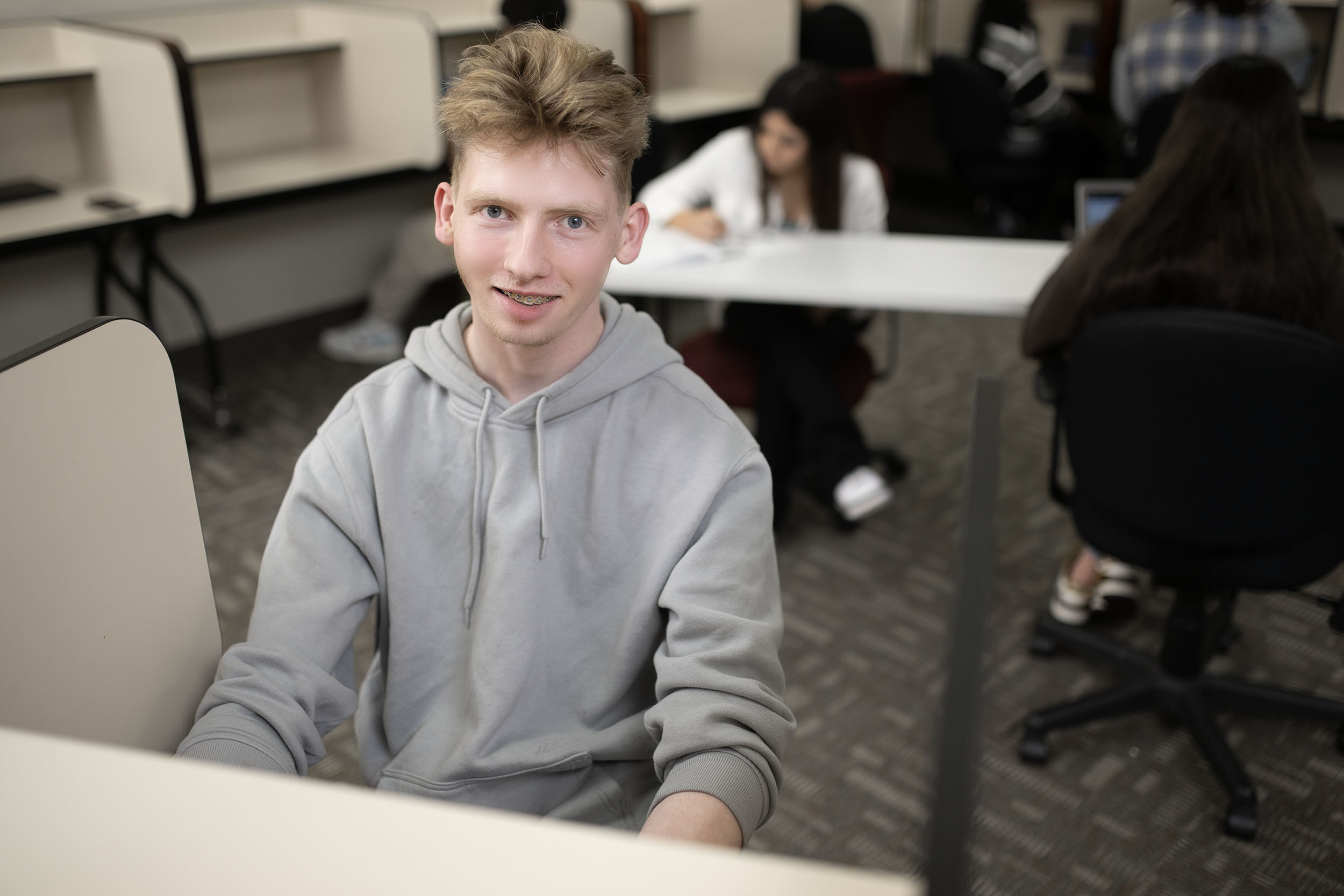 Young man smiling in a classroom setting