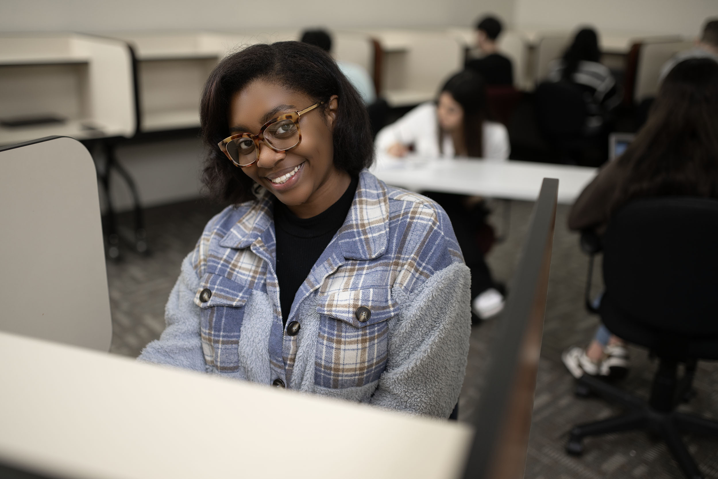 Smiling student sitting in college classroom setting