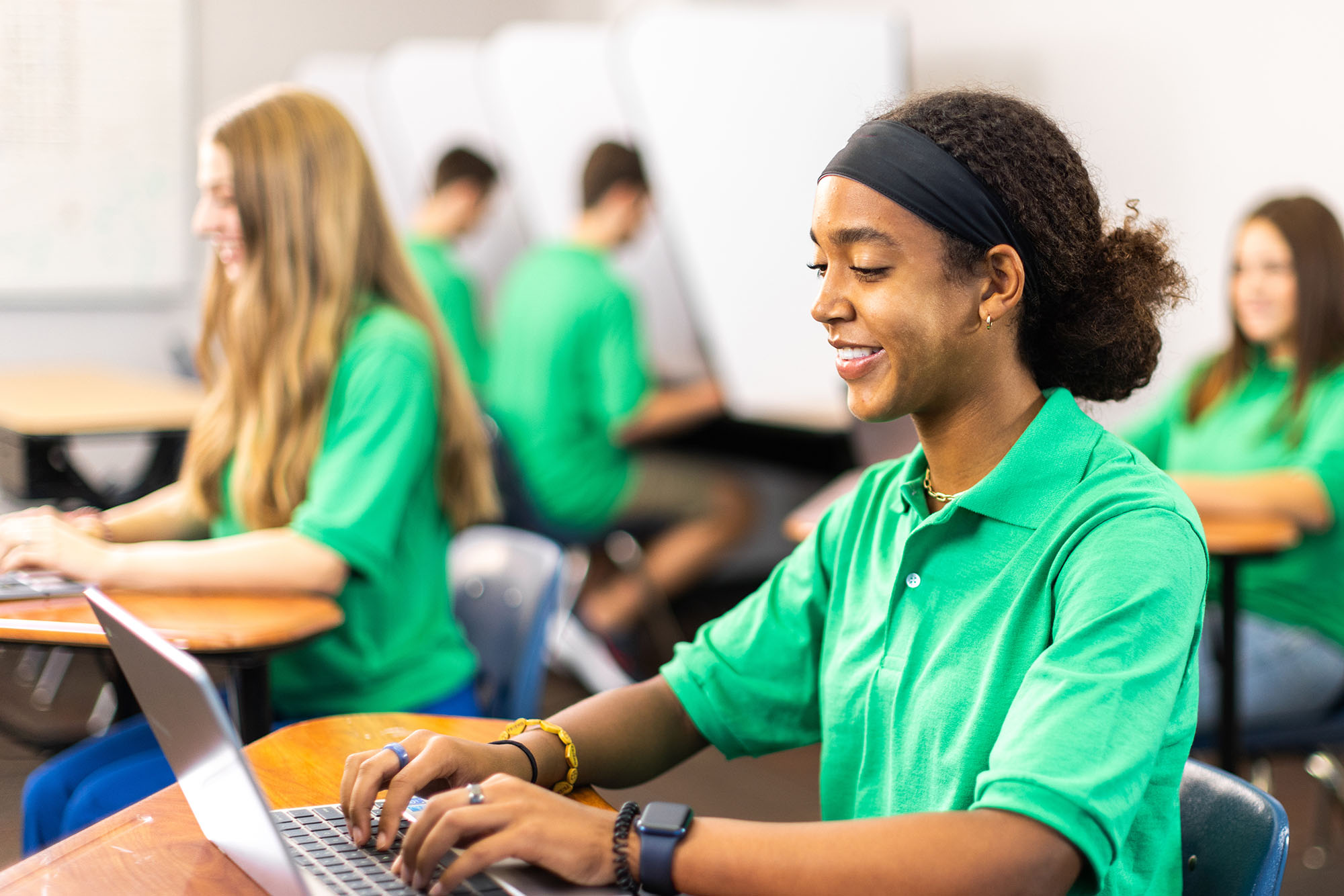 Student using laptop in a classroom setting