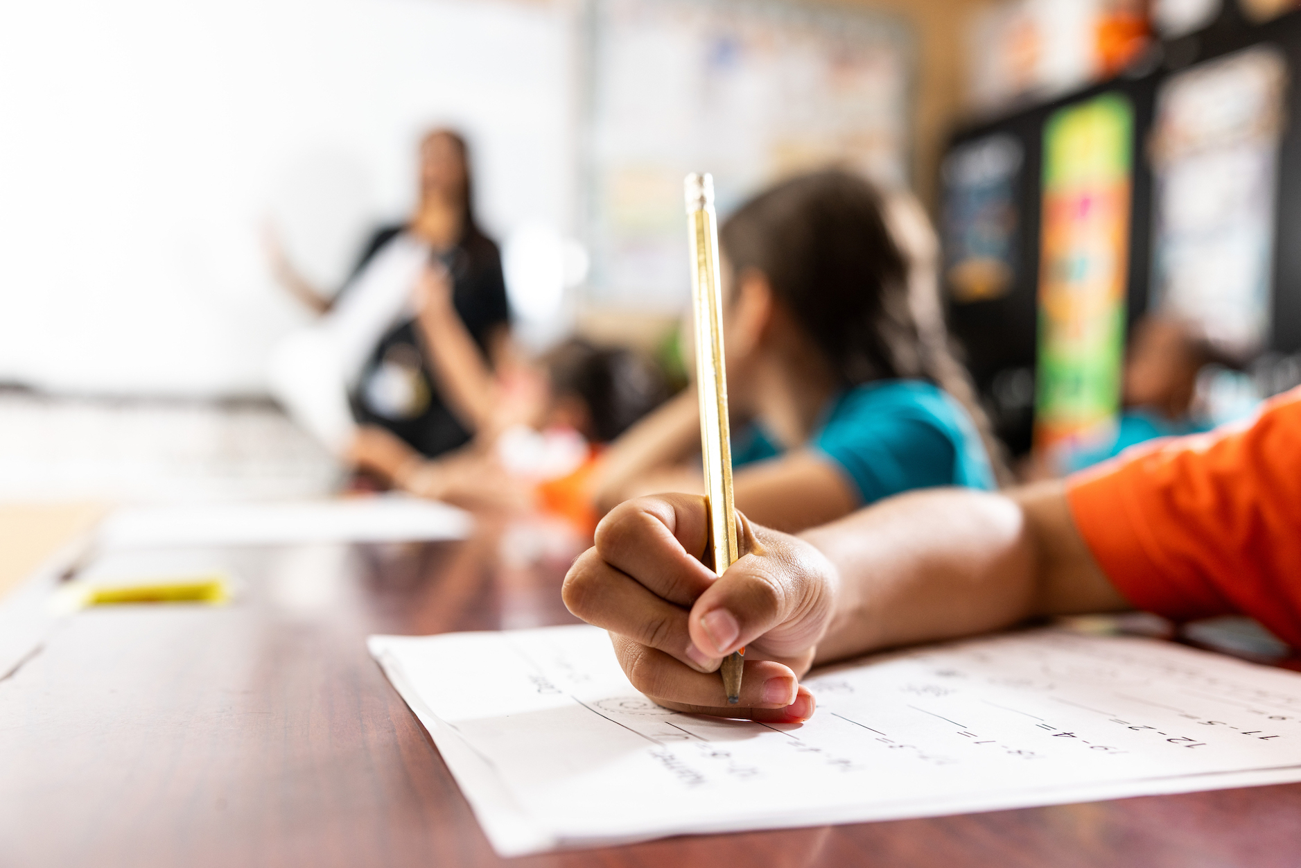 Student writing in classroom during lesson time.
