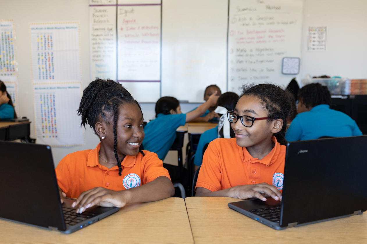 Students collaborating on laptops in classroom setting