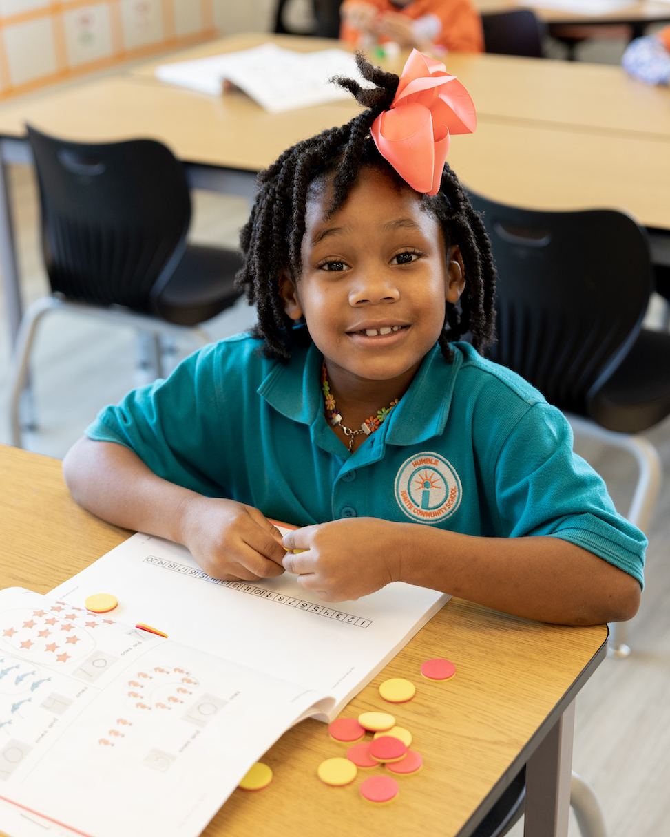Child smiling while sitting in a classroom