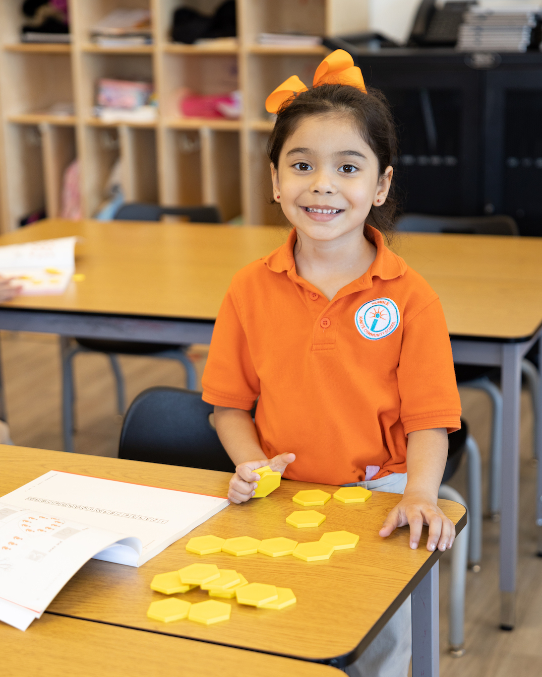 Young girl learning with geometric shapes in classroom