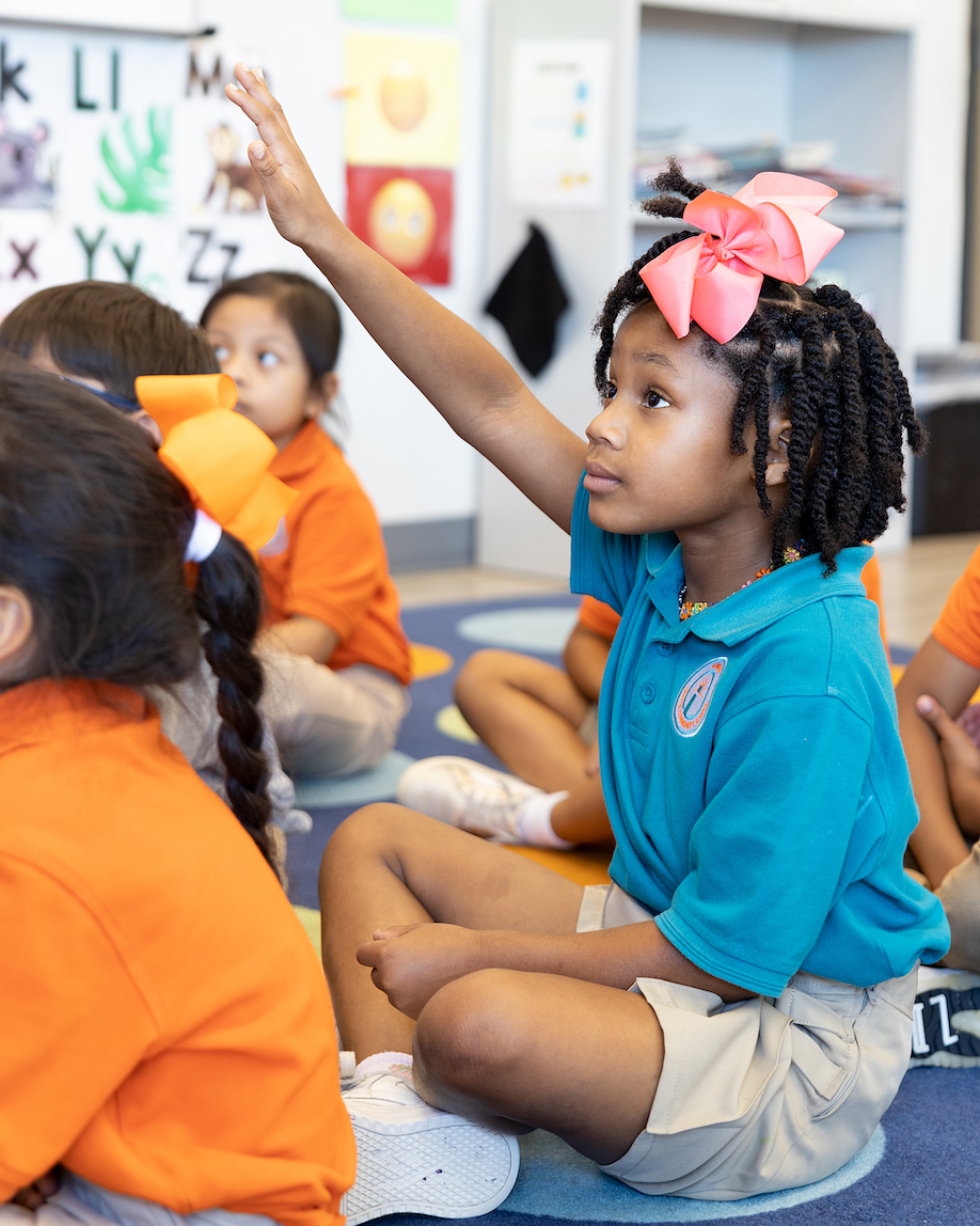Young student raising hand in a classroom
