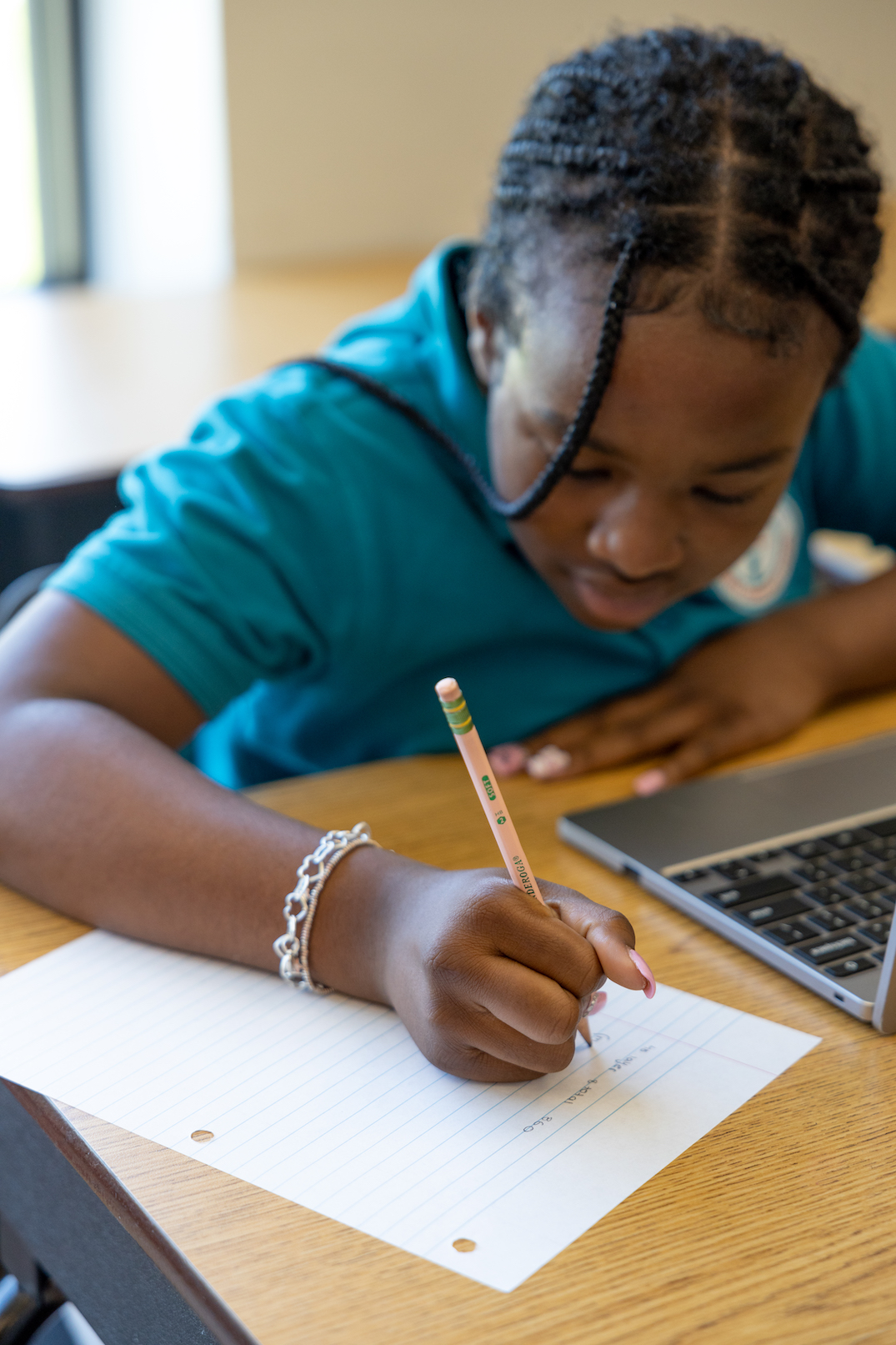 Student writing in notebook during class activity
