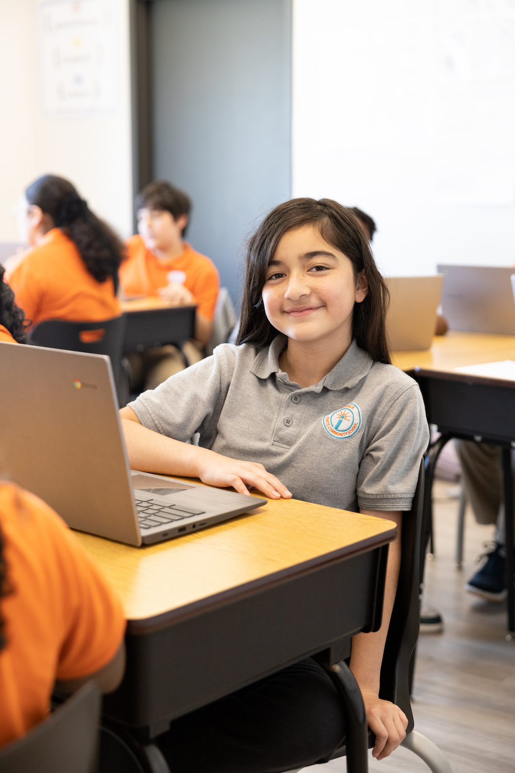 Student smiling in classroom with laptop computer